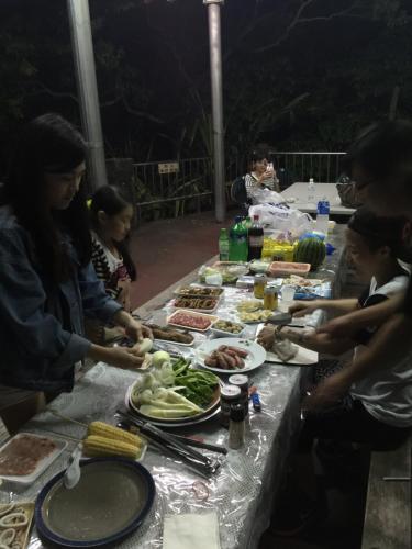 Un groupe de personnes autour d'une table avec de la nourriture dans l'établissement Shan Feng B&B, à Gukeng