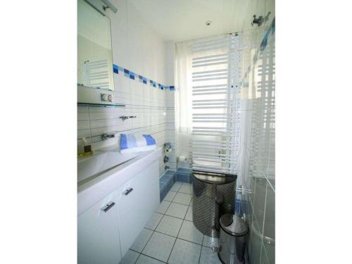 een witte badkamer met een wastafel en een toilet bij Haas Comfortable holiday residence in Wangerooge