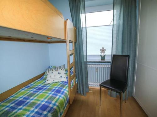 een slaapkamer met een stapelbed met een stoel en een raam bij Haas Comfortable holiday residence in Wangerooge