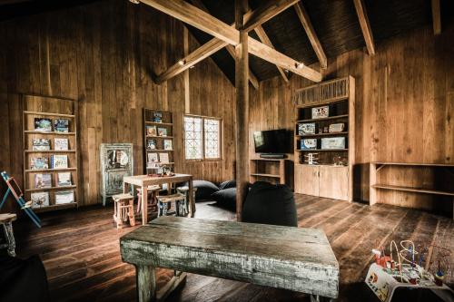 ein Wohnzimmer mit Holzwänden und einem Tisch in der Unterkunft Zannier Phum Baitang in Siem Reap