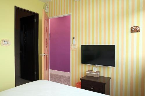 a bedroom with a bed and a tv on a wall at Dora's World in Jian