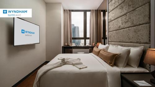 Habitación de hotel con cama y TV en Wyndham Suites KLCC, en Kuala Lumpur