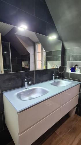 une salle de bain avec deux lavabos et un grand miroir dans l'établissement Maison au coeur du bocage normand Gourfaleur, à Bourgvallées
