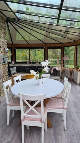- une table et des chaises blanches dans la chambre dans l'établissement Maison au coeur du bocage normand Gourfaleur, à Bourgvallées