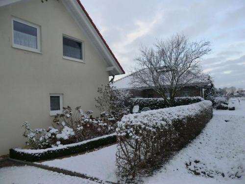 a house with snow on the ground next to a yard at Schwalbennest Comfortable holiday residence in Perrich