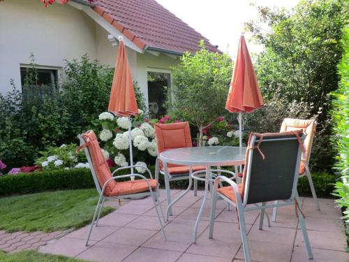 a patio with a table and chairs and umbrellas at Schwalbennest Comfortable holiday residence in Perrich