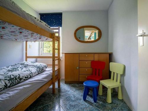 - une chambre avec des lits superposés et 2 chaises dans l'établissement Huijsmans Verhuur Type de Luxe Plus Mosselbank, à Ouddorp