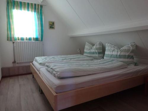 a large bed in a bedroom with a window at Huijsmans Verhuur Type de Luxe Haringvliet 28 in Ouddorp
