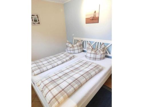 duas camas num quarto com lençóis de xadrez em Boddensurfer 2a Comfortable holiday residence em Pruchten
