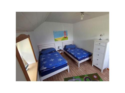 una piccola camera con due letti e un comò di Friesenblick Comfortable holiday residence a Buttforde