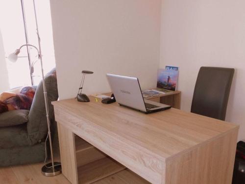 a laptop on a wooden table in a living room at Neuer Hafen - 180° unverbauter Traumblick in Bremerhaven
