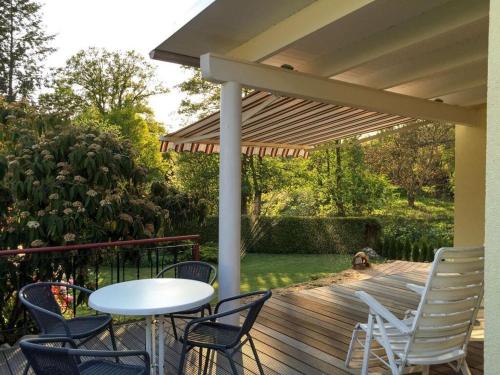 a wooden deck with a table and chairs and an umbrella at Göwe Comfortable holiday residence in Weberin