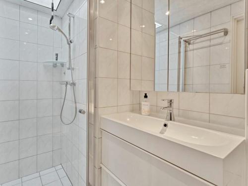 Un baño blanco con lavabo y ducha. en Holiday home Huijsmansverhuur, en Ouddorp