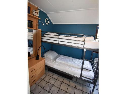 two bunk beds in a room with a blue wall at Huijsmansverhuur Type de Luxe plus Haringvliet 173 in Ouddorp