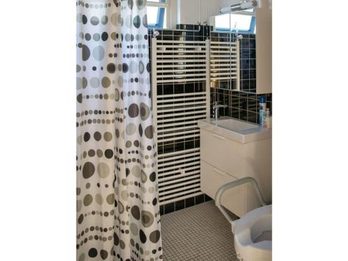 Un baño con inodoro y cortina de ducha. en Huijsmans Verhuur Type C Comfort Plus, en Ouddorp