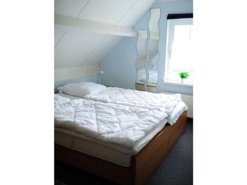 a bed in a room with a window at Huijsmansverhuur Type Premium de Luxe in Ouddorp