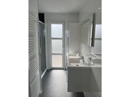 ein Bad mit 2 Waschbecken und einem Fenster in der Unterkunft Chalet IJsselmeerstrand First row in Enkhuizen