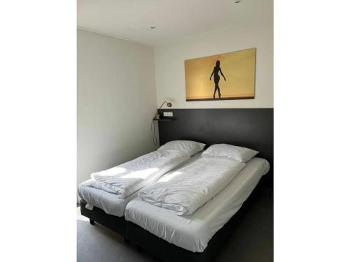 een bed in een kamer met een foto aan de muur bij Chalet IJsselmeerstrand First row in Enkhuizen