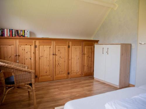 a bedroom with wooden cabinets and a white refrigerator at Huijsmans Verhuur Type Deluxe Zuiderdiep 11 in Ouddorp