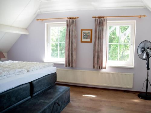 a bedroom with a bed and two windows at Huijsmansverhuur Type Premium de Mosselbank 115 in Ouddorp