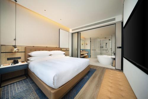 a bedroom with a large bed and a bath tub at Four Points by Sheraton Chengdu, High-Tech Zone Exhibition Center in Chengdu