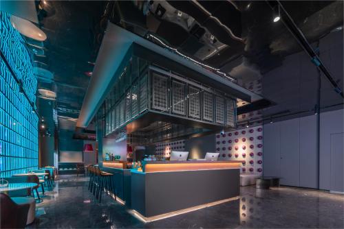 a restaurant with a bar with chairs and tables at CityNote希诺酒店(广州北京路步行街新大新店) in Guangzhou