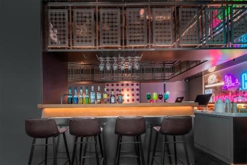 a bar with brown stools in a restaurant at CityNote希诺酒店(广州北京路步行街新大新店) in Guangzhou
