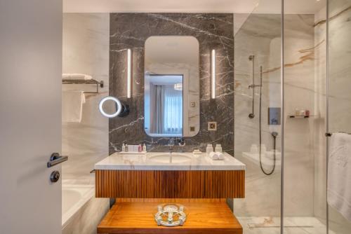 a bathroom with a sink and a shower at Grand Hotel des Bains Kempinski in St. Moritz