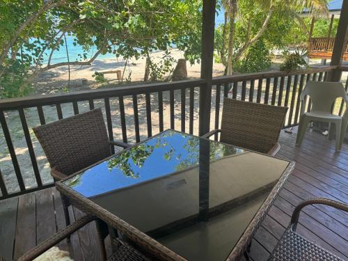 una mesa y sillas en una terraza con vistas a la playa en Parea Lodge Huahine Bungalow 2#FETI'A en Parea