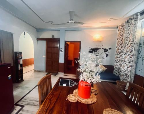 una sala de estar con una mesa de madera con flores. en Ganga Vatika Boutique Hotel, Rishikesh, en Rishīkesh