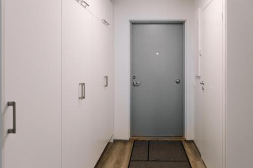 a hallway with white walls and a door at Forenom Serviced Apartments Lahti Hennala in Lahti