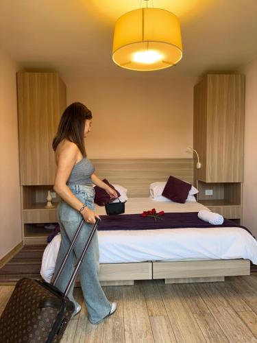 uma mulher num quarto de hotel com uma cama em HOtello guest suites em Jounieh