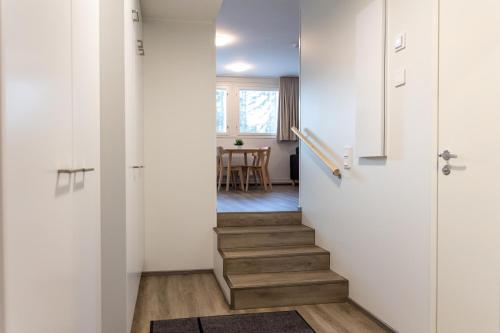 a hallway with stairs leading to a dining room at Forenom Serviced Apartments Lahti Hennala in Lahti