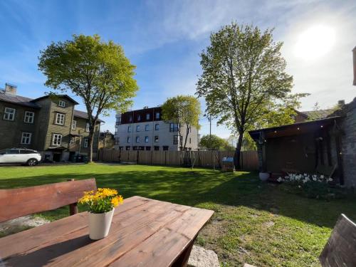 a wooden picnic table in a yard with a building at Garden Studio next to Telliskivi & Old Town in Tallinn