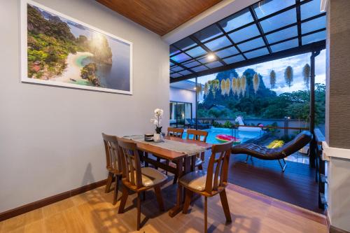 a dining room with a table and chairs and a large window at Sea Eagle Mountain private pool villa Aonang in Ban Nong Thale