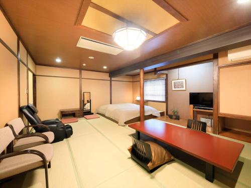 a bedroom with a bed and a desk in a room at Saikatei Jidaiya in Kaminoyama