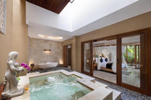 een kamer met een bad en een slaapkamer bij The Sankara Suites and Villas by Pramana in Ubud