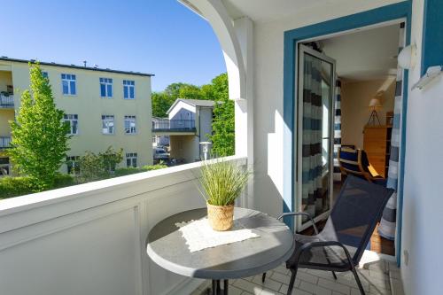 einen kleinen Tisch auf einem Balkon mit Blick auf ein Gebäude in der Unterkunft Haus Holstein - WG 6 mit Balkon, strandnah in Ostseebad Sellin
