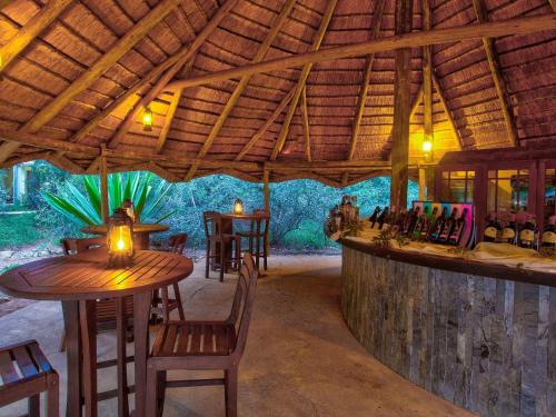 a restaurant with a bar with tables and chairs at Kubu Safari Lodge in Hoedspruit