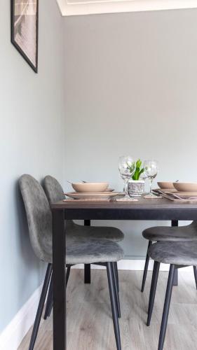 a dining room table with chairs and glasses on it at Blairmuire House in Broxburn