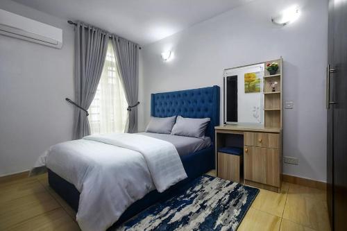 a bedroom with a bed with a blue headboard and a window at Crib 6 in Lagos