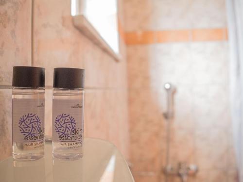 2 botellas sentadas encima de un lavabo en el baño en Apartments Hotel & Studios, Xifoupolis, en Monemvasia
