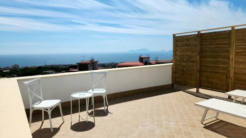 a balcony with two chairs and a view of the ocean at Hotel Sakura in Torre del Greco