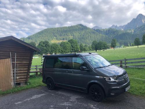 a black van parked in front of a field at Romantikapartment mit Sommercard in Ramsau am Dachstein