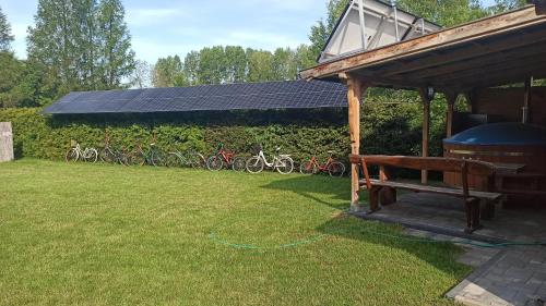 a pavilion with a bench in a yard with bikes at Apartameny Wiktoria i Nikola w Karwiku in Pisz