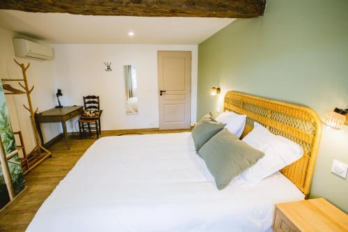 a bedroom with a large bed with white sheets and pillows at Gîte Ô Tilleul Enchanté in Lamonzie-Saint-Martin