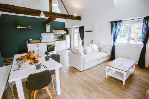 - un salon avec une table blanche et un canapé blanc dans l'établissement Gîte Ô Tilleul Enchanté, à Lamonzie-Saint-Martin