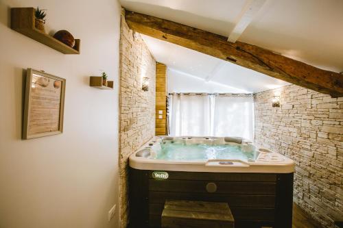 a bathroom with a jacuzzi tub with a window at Gîte Ô Tilleul Enchanté in Lamonzie-Saint-Martin