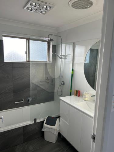 a bathroom with a shower and a sink and a mirror at Waters Edge Golden Sunrise Two Bedroom Apartment Recent Reno in Rocky Point