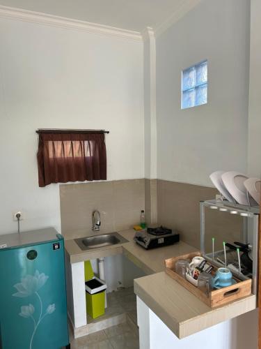 a kitchen with a sink and a counter top at D'uma Amed Homestay in Amed